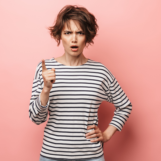 women striped shirt shaking finger, peach background, freakyhealer energetic insight blog post