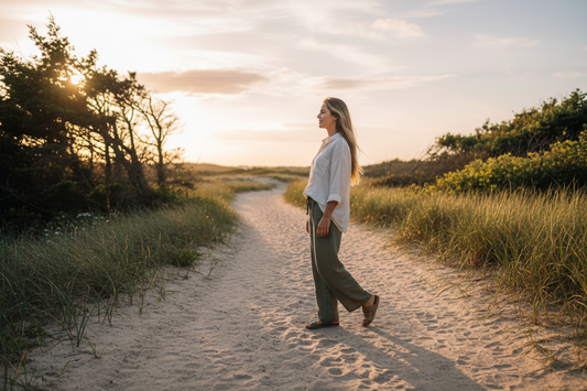 Woman walking with purpose on beach path at golden hour — finding your purpose after 40