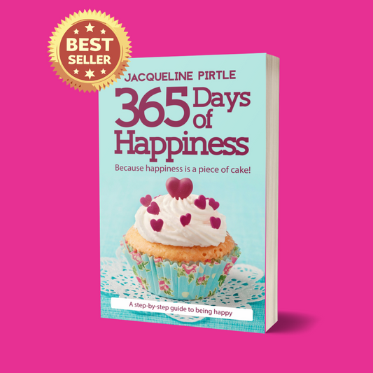 Paperback copy of 365 Days of Happiness book with colorful cover featuring smiling faces, vibrant yellow and teal design