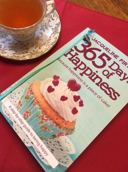 Close-up of the book's textured pastel pink cover with embossed title and subtle matte finish, showing detailed surface