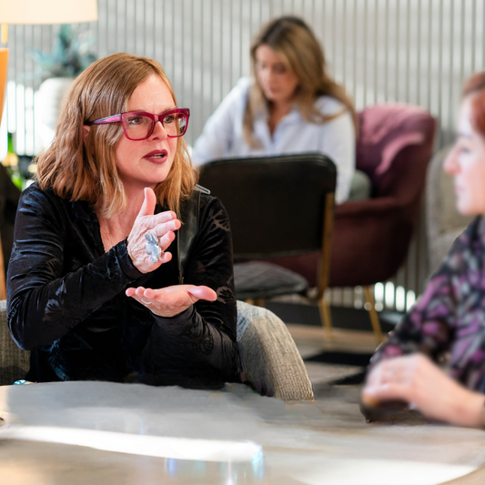 Jacqueline speaking animatedly with a woman about energy work and transformation